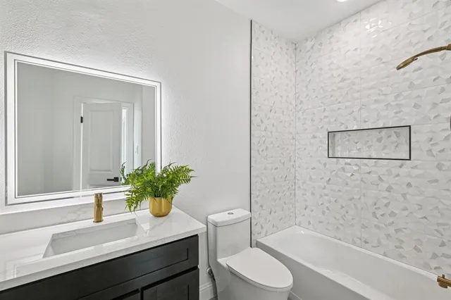 a bath room with a toilet a sink and a bath tub