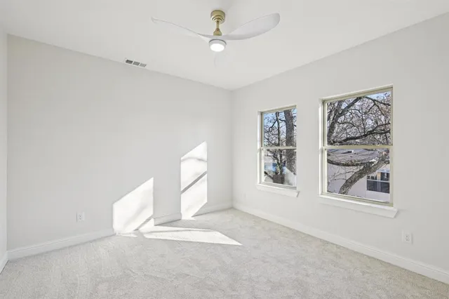 an empty room with windows and cabinet