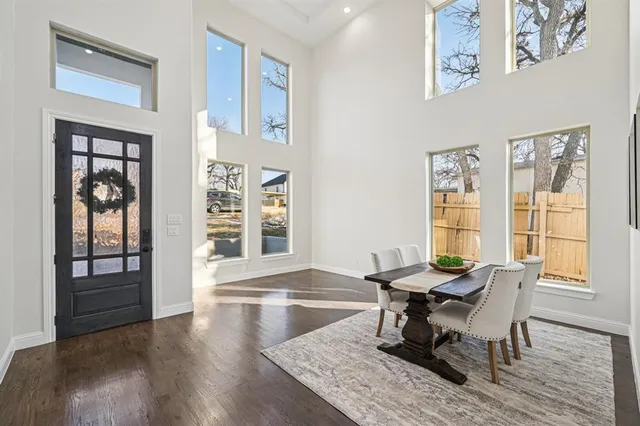 a dining room with wooden floor and windows