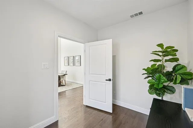 a view of a hallway with wooden floor and a potted plant