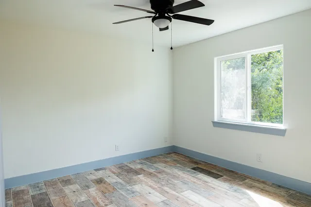 a view of a room with a window and a ceiling fan