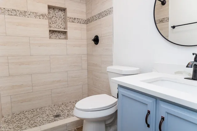 a bathroom with a sink a toilet and shower