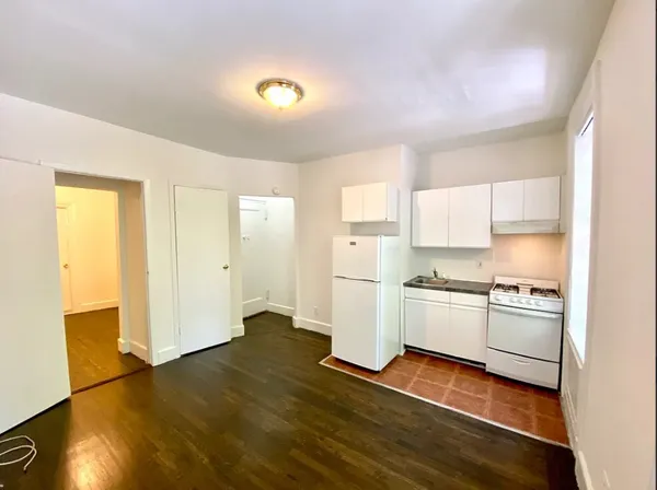 a kitchen with a refrigerator and a stove top oven