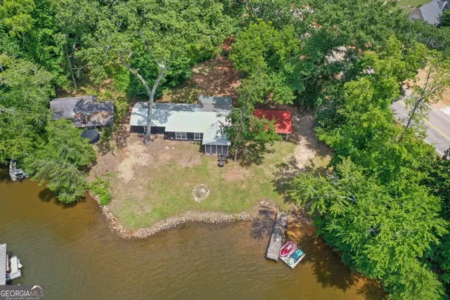 an aerial view of a house with a yard and lake view