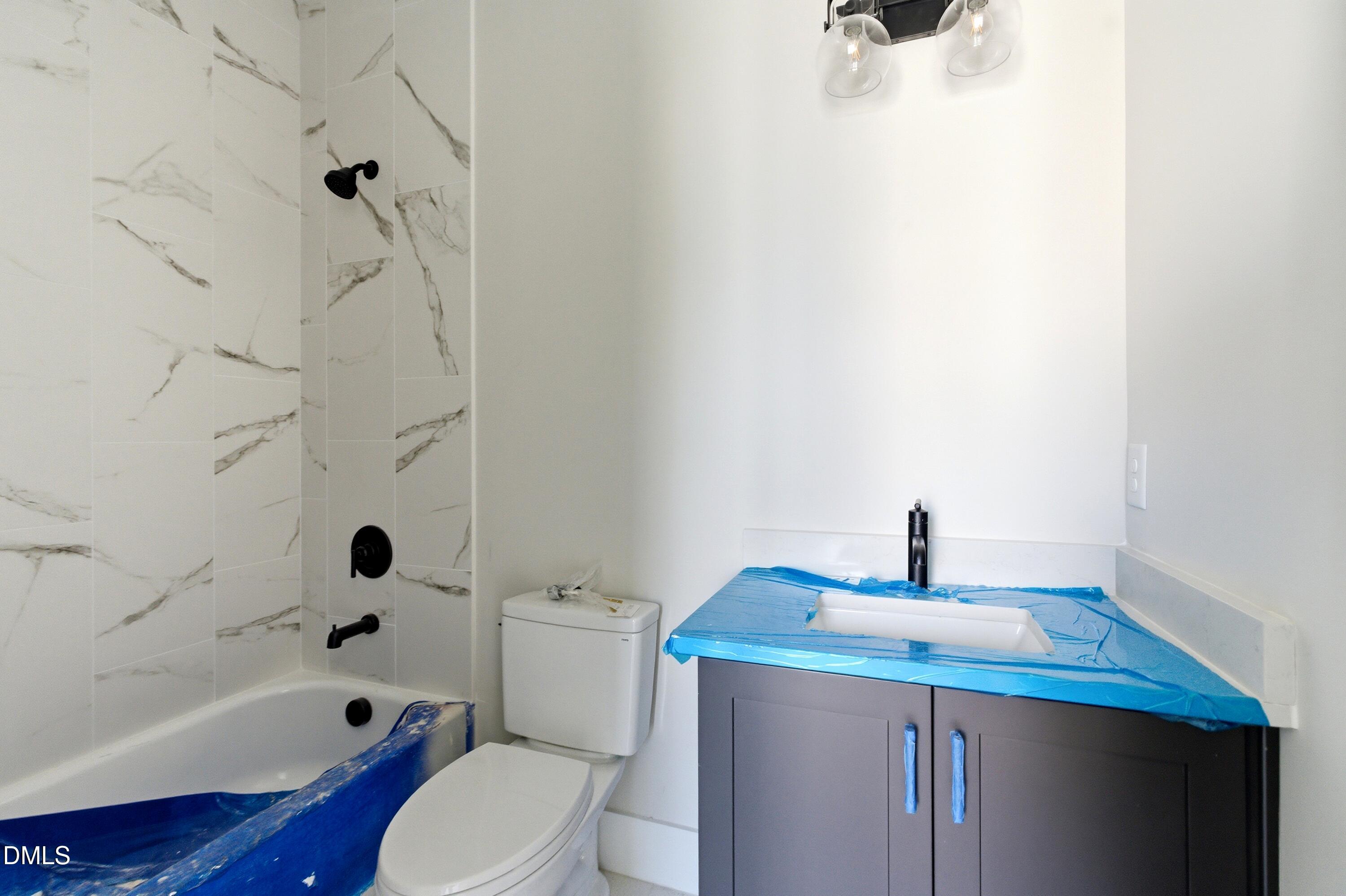 720 Noble Town Way, Unit 104 Raleigh, NC 27603 - Photo 16 of 21 a bathroom with a sink a toilet and shower