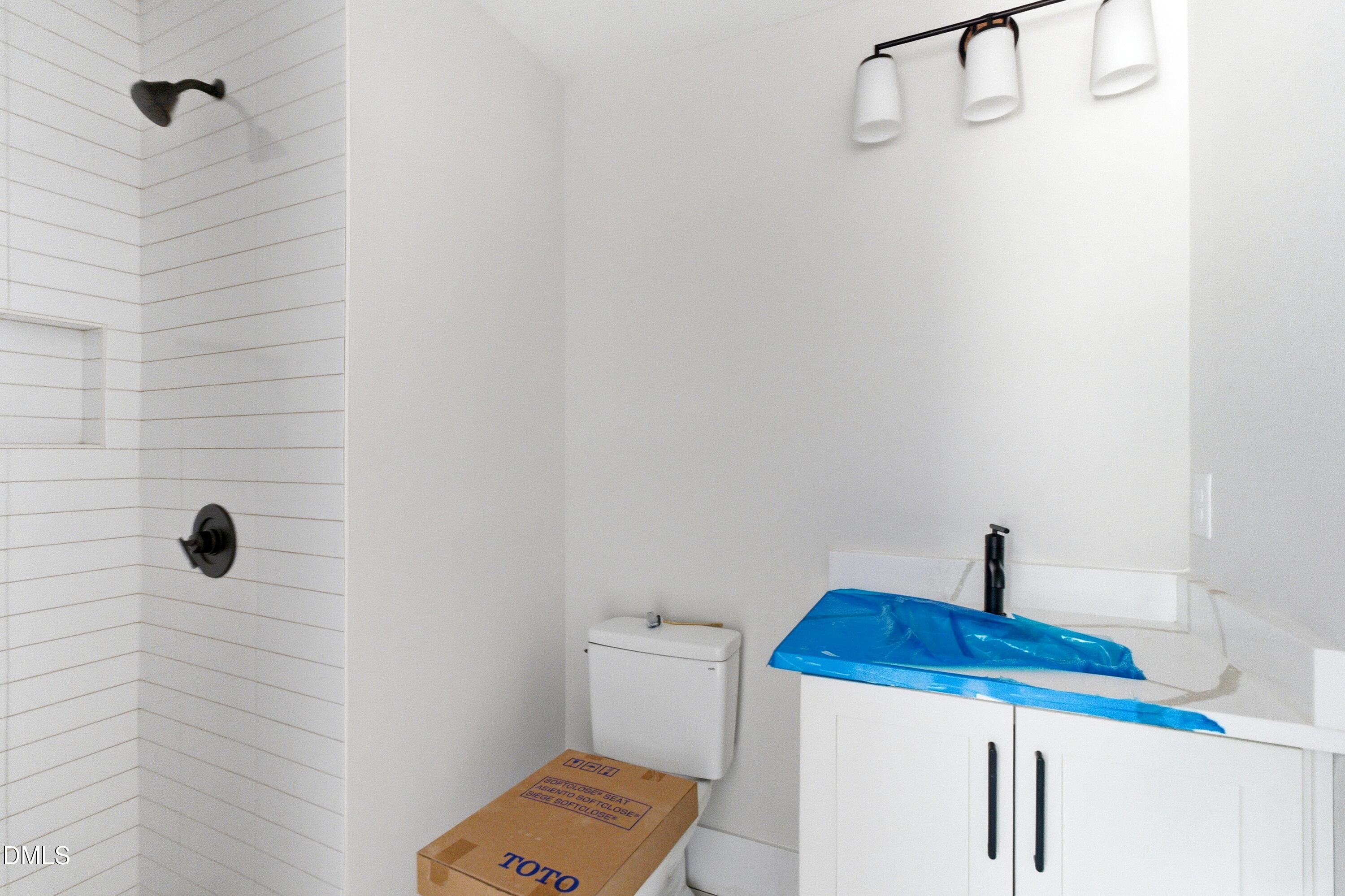720 Noble Town Way, Unit 104 Raleigh, NC 27603 - Photo 10 of 21 a bathroom with a sink a toilet and shower