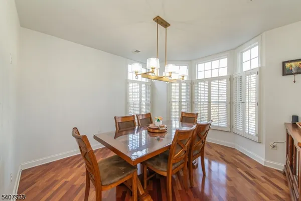 a dining hall with stainless steel appliances granite countertop a stove granite counter tops and a view of living room