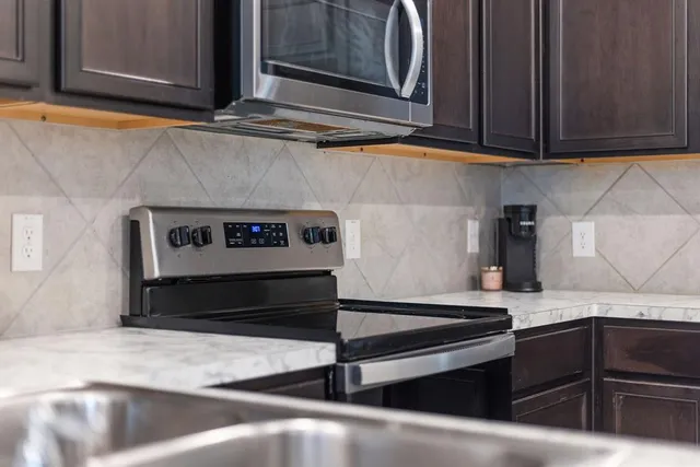 a kitchen with granite countertop a stove and cabinets