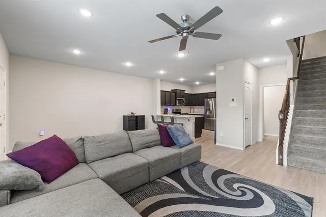 a living room with furniture and a view of kitchen