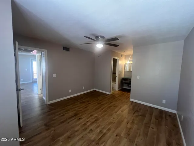 a view of an empty room with wooden floor