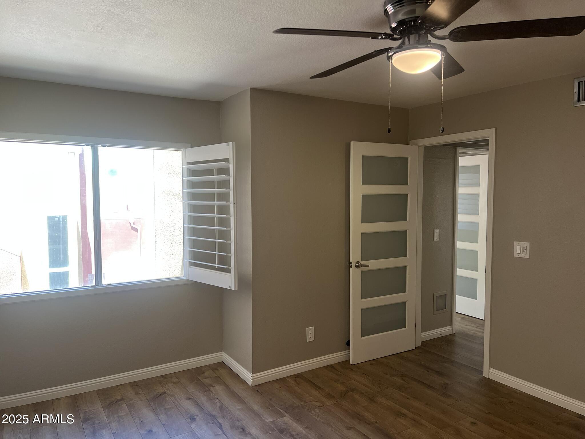 154 West 5th Street, Unit 248 Tempe, AZ 85281 - Photo 12 of 18 a view of an empty room with a window and wooden floor