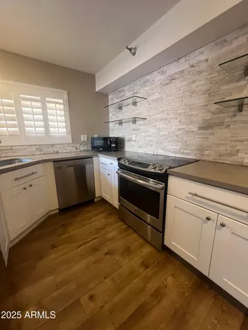 a kitchen with stainless steel appliances granite countertop a stove and a sink