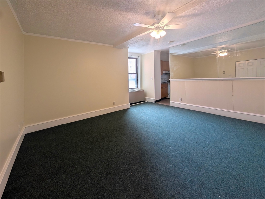140 Chestnut Street, Unit 207 Springfield, MA 01103 - Photo 3 of 13 an empty room with windows and fan
