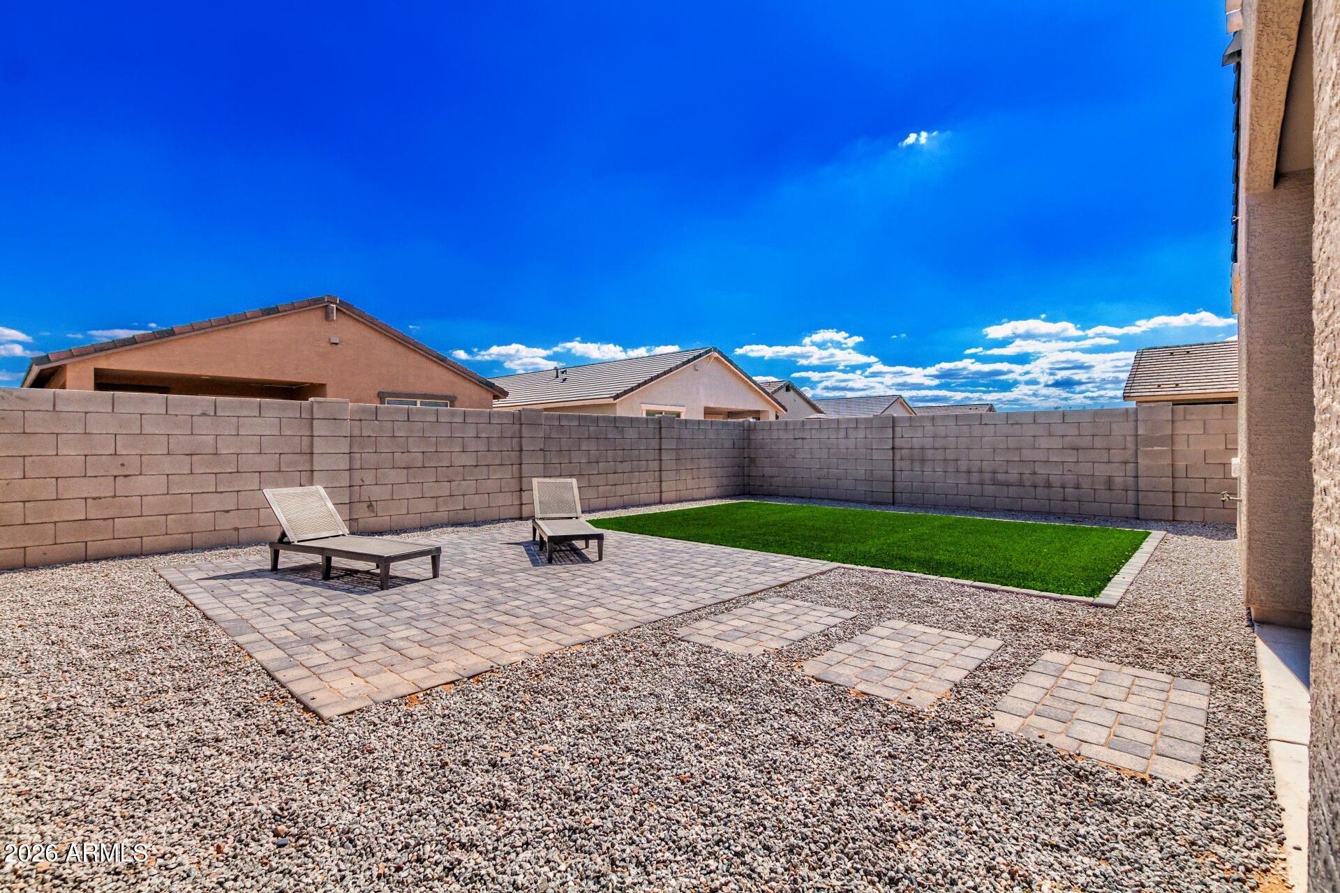 39985 West Rio Lobo Drive Maricopa, AZ 85138 - Photo 25 of 44 a backyard of a house with table and chairs