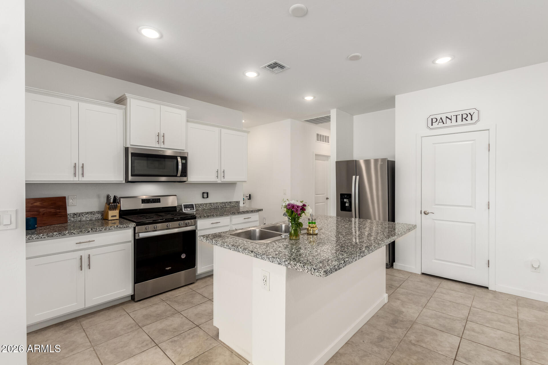 39985 West Rio Lobo Drive Maricopa, AZ 85138 - Photo 8 of 44 a kitchen with stainless steel appliances granite countertop a refrigerator sink and stove