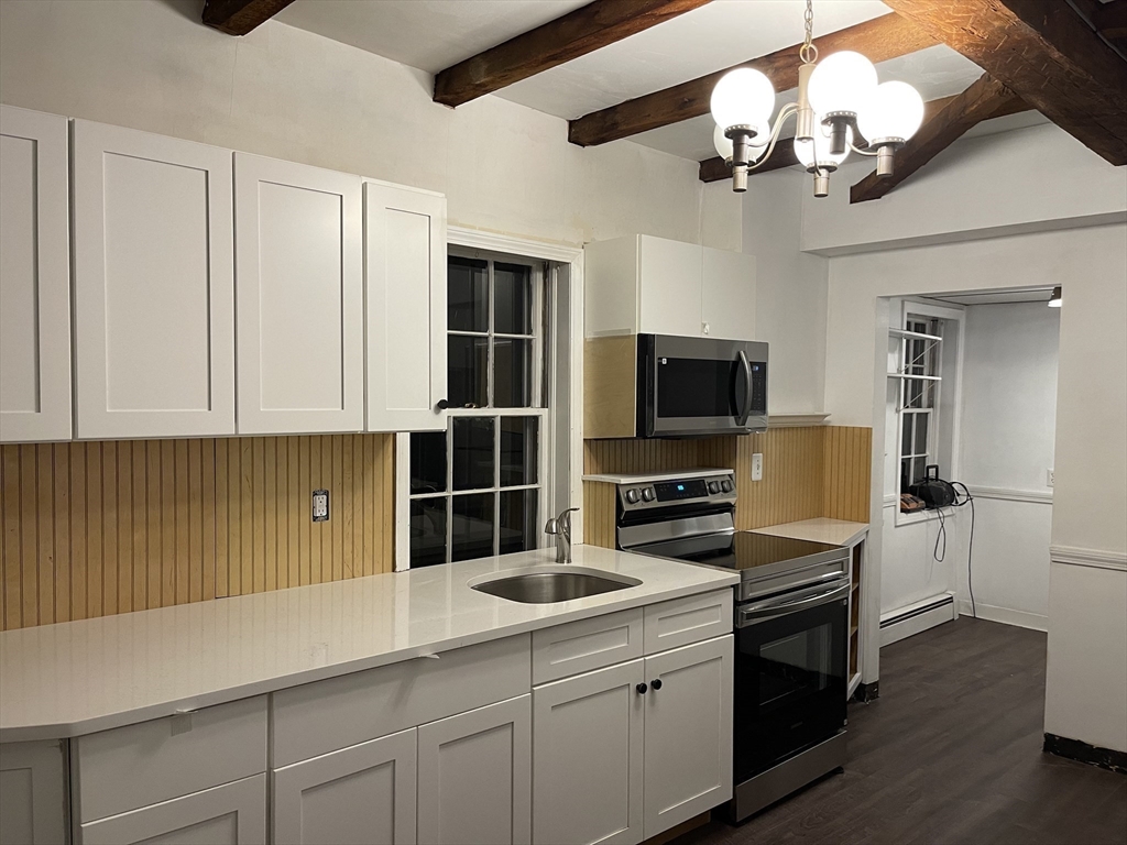 37 Turner Street, Unit 2 Salem, MA 01970 - Photo 2 of 9 a kitchen with a sink stainless steel appliances and chandelier