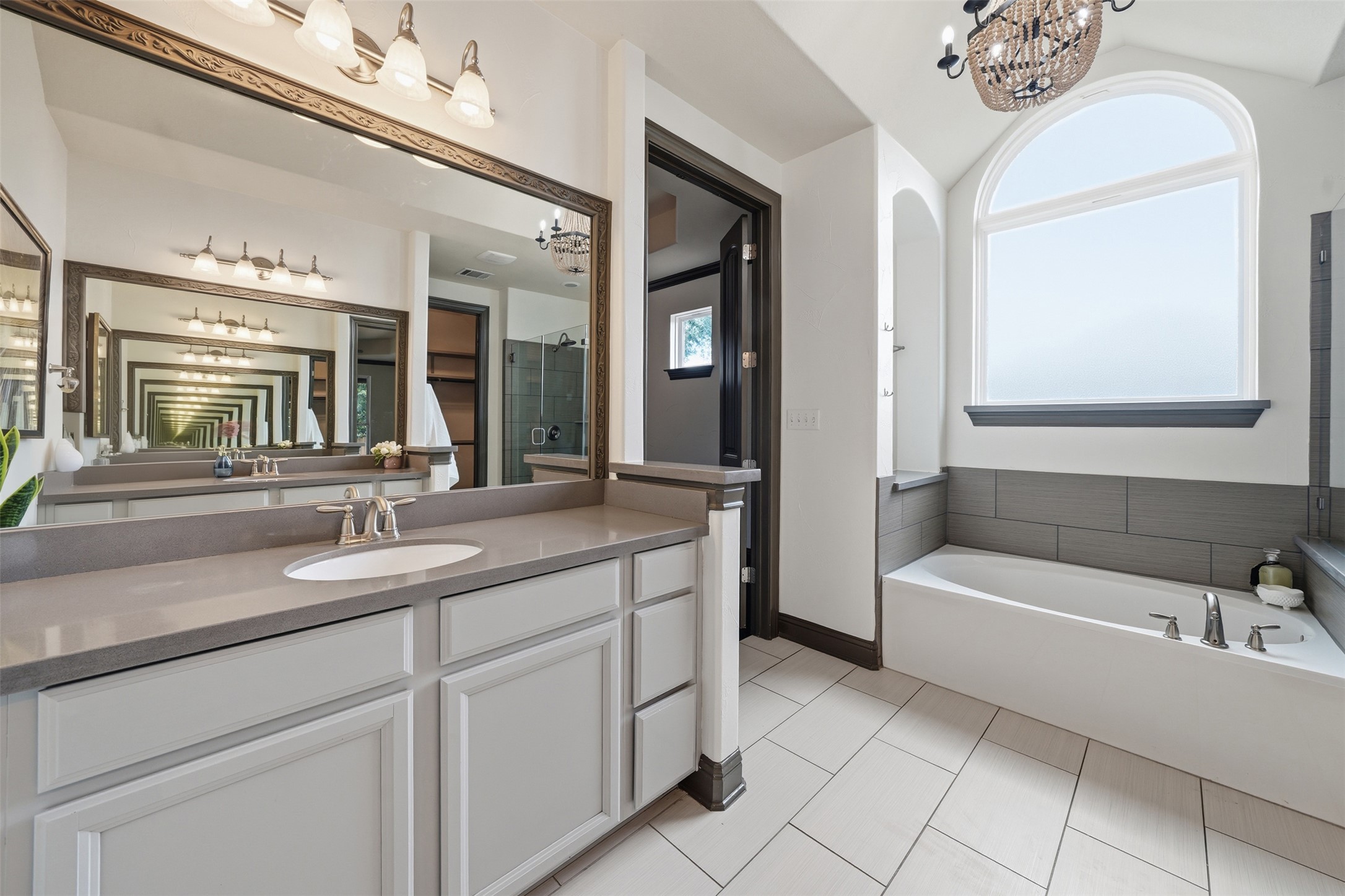 8729 Vantage Point Drive Austin, TX 78737 - Photo 20 of 33 Luxurious bathroom with ample counter space and a deep soaking tub beneath an arched window.