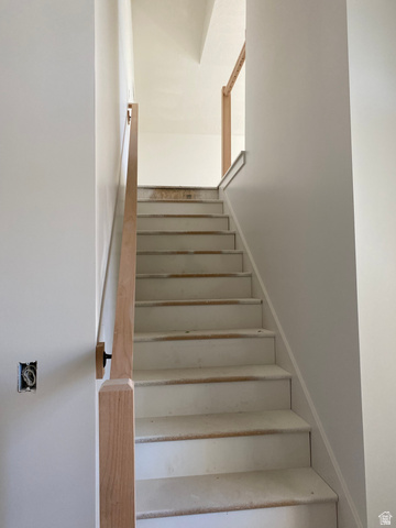 4676 West 75 North, Unit 401 West Point, UT 84015 - Photo 12 of 17 Staircase featuring light wood handrails, white risers, and light-colored treads
