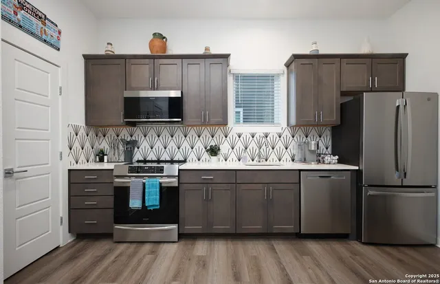 a kitchen with stainless steel appliances a stove a sink and a refrigerator