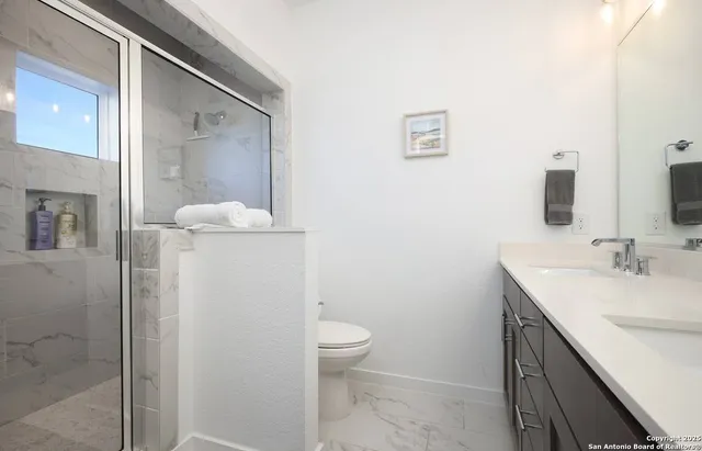 a bathroom with a sink a toilet and shower