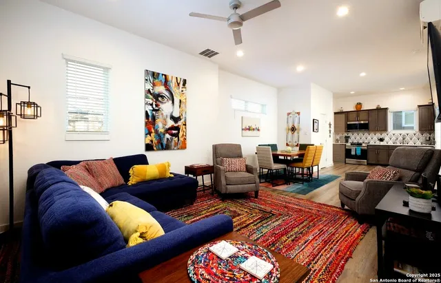 a living room with furniture kitchen view and a window