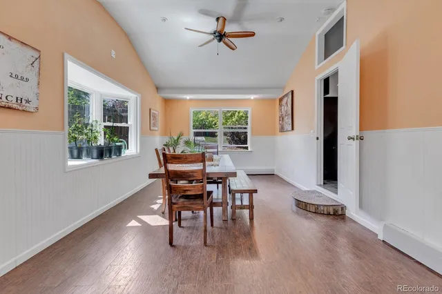 a dining room with wooden floor a chandelier a glass table and chairs