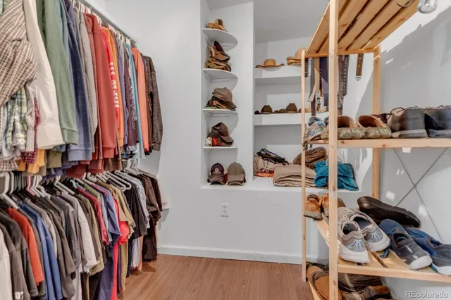 a view of walk in closet with clothes and shoes