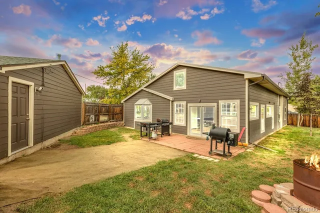 a view of a house with backyard and sitting area
