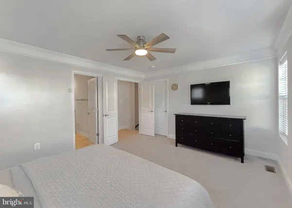 a bedroom with a bed and a flat tv screen on dresser