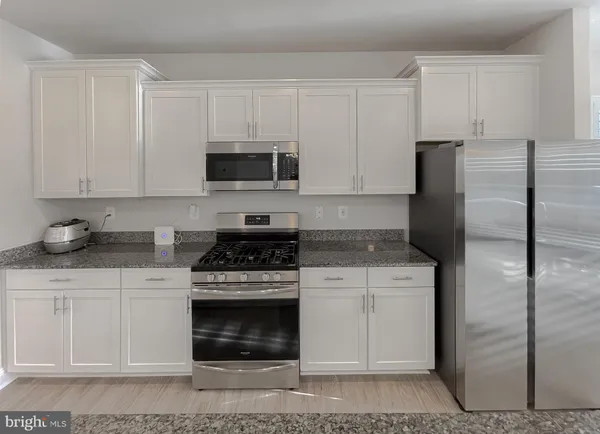 a kitchen with cabinets stainless steel appliances and a counter space