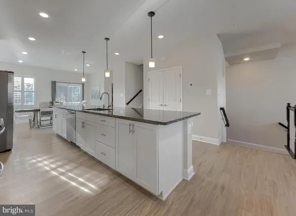 a kitchen with stainless steel appliances kitchen island a sink and a refrigerator
