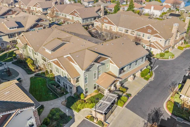 a front view of a house with garden and chairs