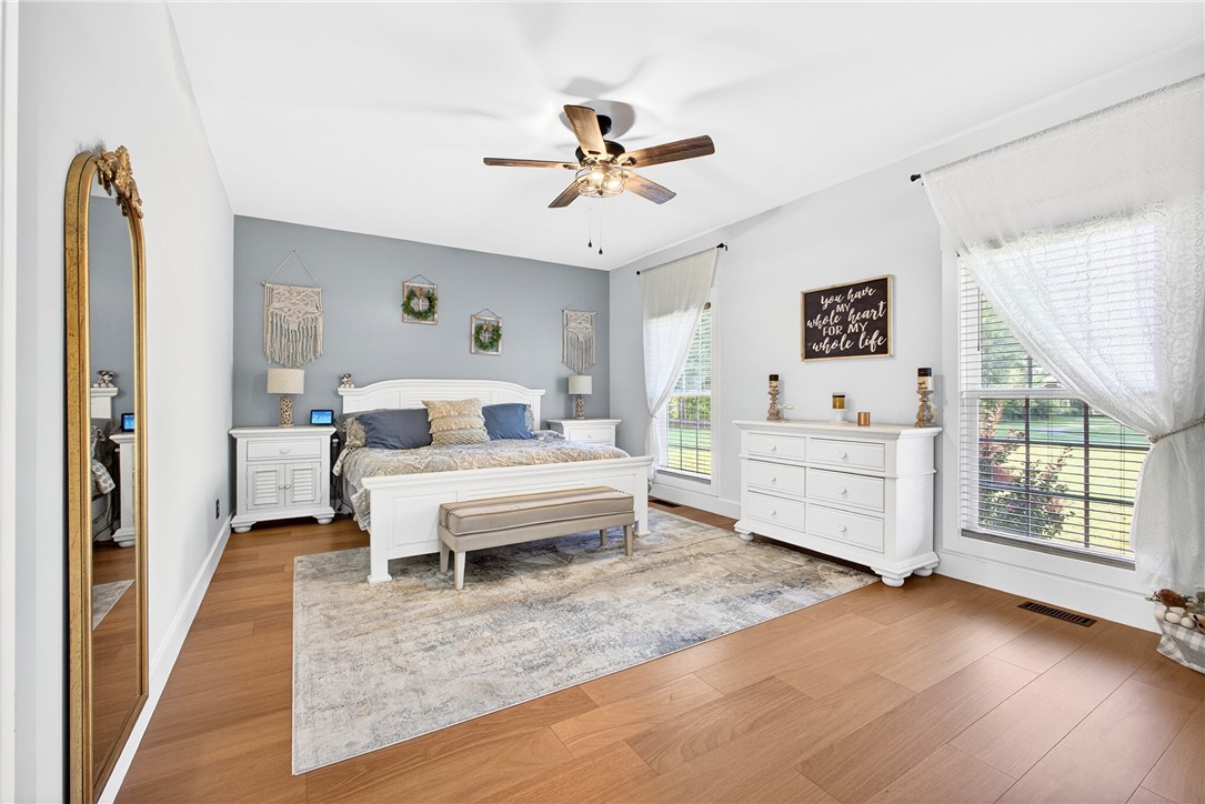 5016 Copeland Road Belton, SC 29627 - Photo 15 of 45 Elegant hardwood flooring grounds this spacious bedroom, offering abundant natural light and an inviting atmosphere.