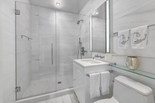 a bathroom with a sink toilet vanity and shower