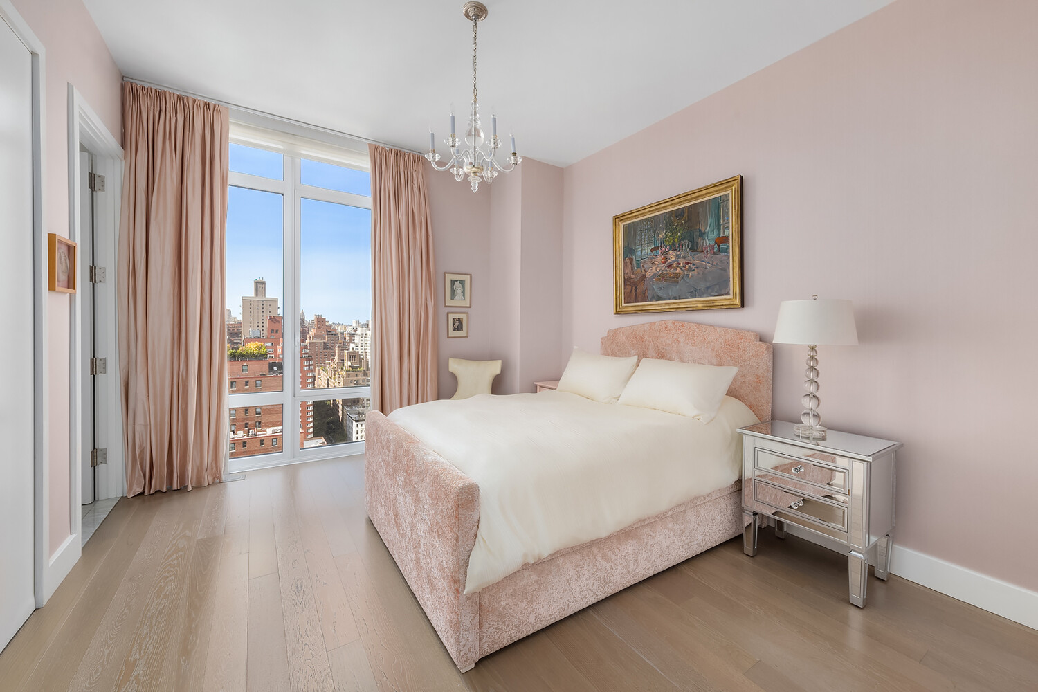 1355 1st Avenue, Unit 22 Manhattan, NY 10021 - Photo 9 of 16 a spacious bedroom with a bed and a chandelier