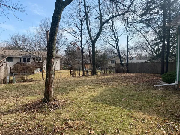 a yard with trees in the background