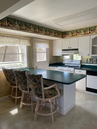 a kitchen with granite countertop a table and chairs in it