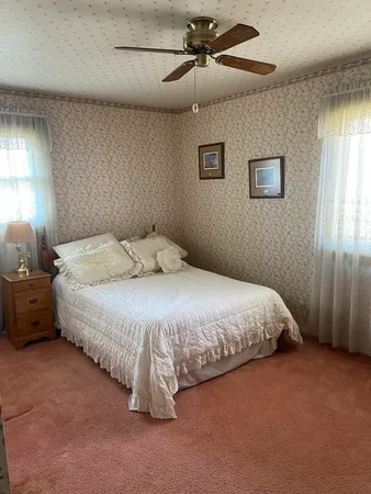 a room with a bed and dresser with mirror