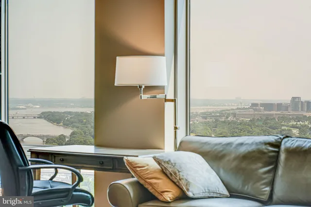 a living room with a couch and floor to ceiling window