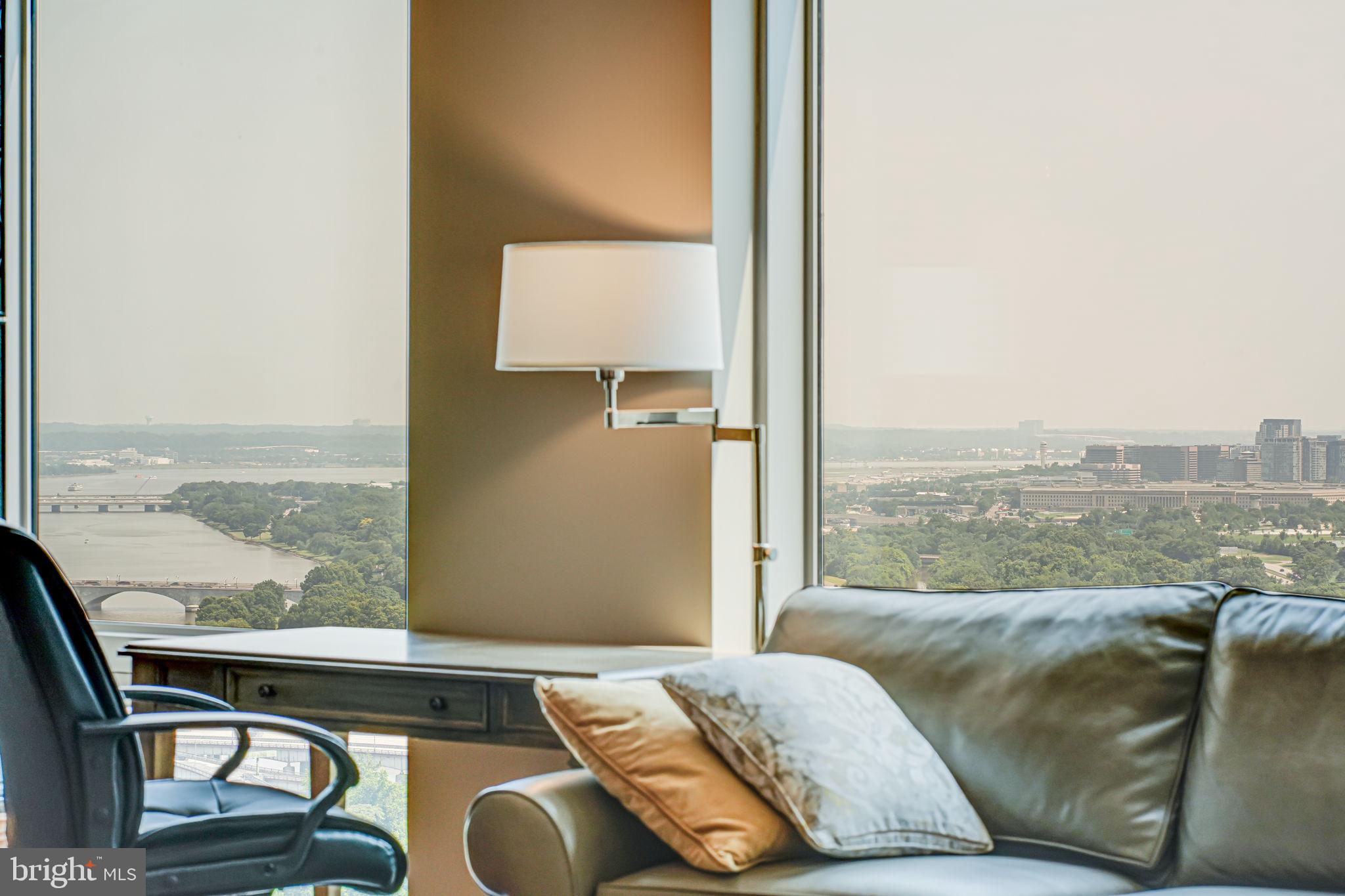 a living room with a couch and floor to ceiling window