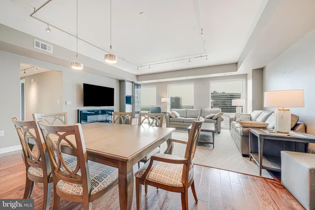 a view of a dining room with furniture wooden floor and a flat screen tv