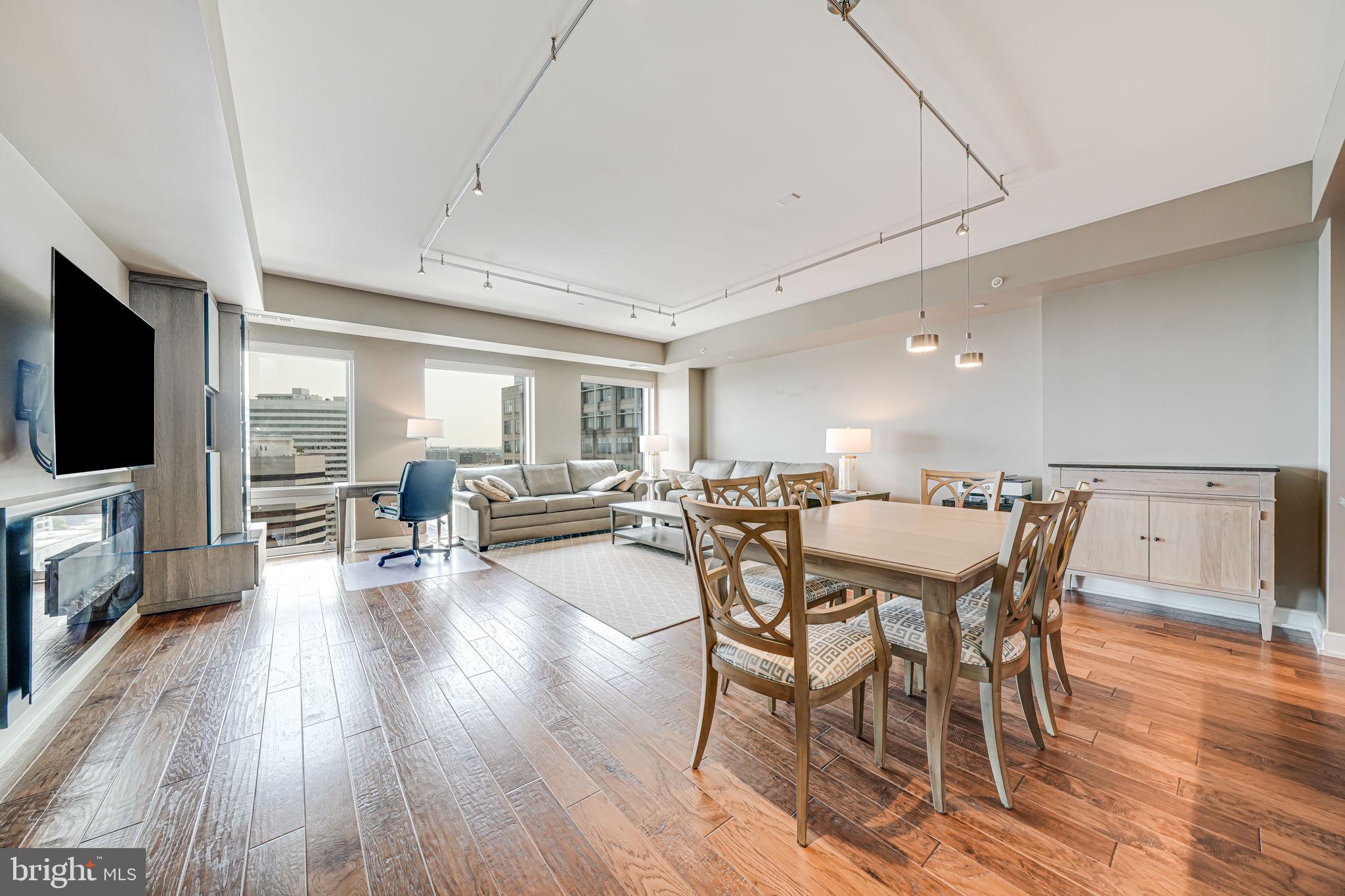 1111 19th Street North, Unit 2703 Arlington, VA 22209 - Photo 12 of 52 a view of a dining room with furniture wooden floor and flat screen tv