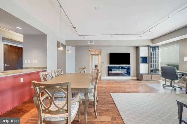 a living room with furniture a flat screen tv and a table