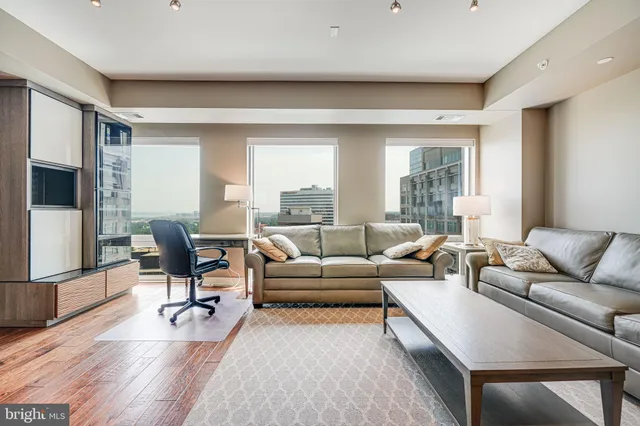 a living room with furniture wooden floor and a flat screen tv