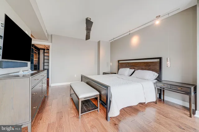 a bedroom with a bed and a flat tv screen on dresser