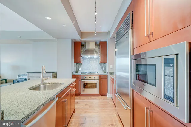 a kitchen with stainless steel appliances granite countertop a sink and a refrigerator