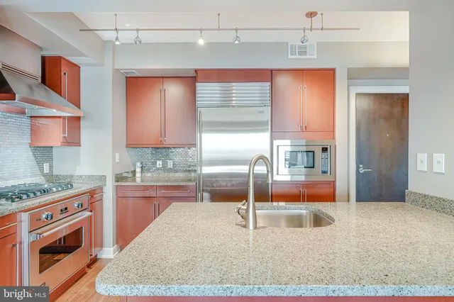 a kitchen with granite countertop a sink a stove and cabinets