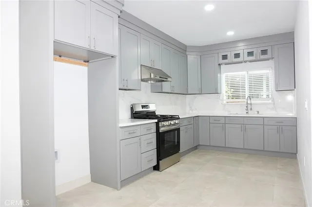 a kitchen with a sink stove top oven and cabinets