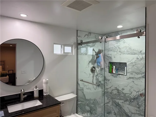 a bathroom with a sink a toilet and a mirror