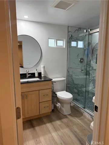 a bathroom with a toilet sink a mirror and shower